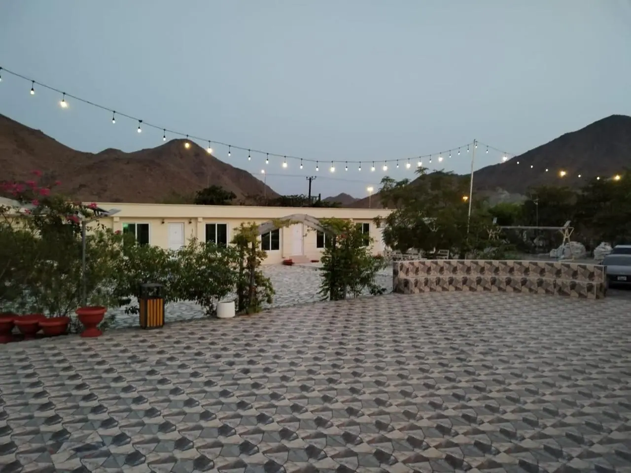 Break House courtyard with string lights and the mountains behind