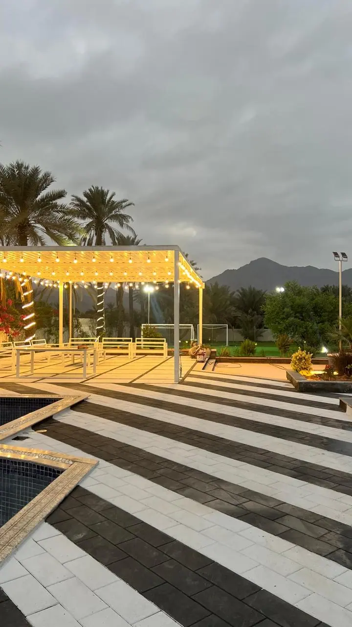 Farm 50 pergola and outdoor seating at dusk, with the mountains behind